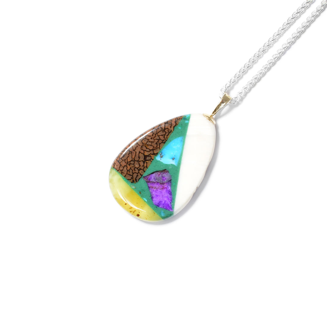 Pear shape. Pendant is a mosaic of sugilite, rhodochrosite, lapis, malachite, dinosaur bone, turquoise, amber, mammoth ivory and ammolite. 14K gold bail.