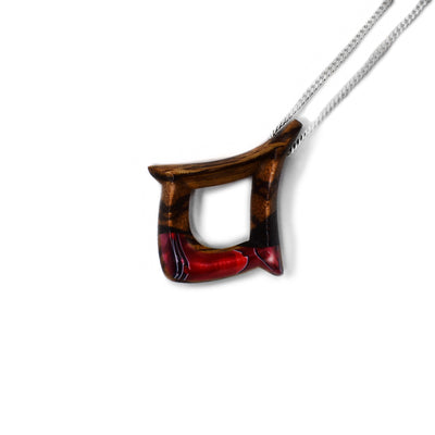 Red side of pendant. Made of wood with black stripes. Shimmering red design on bottom. Sterling silver chain included.