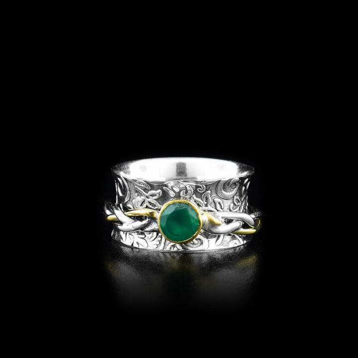 This gorgeous spinner ring is made form sterling silver, brass and green onyx gemstone. There is a wide, silver band with spiral designs made on the surface of it and a braided, silver brass ring over top of the band. The braided piece made from wires can spin around the band and the gemstone is held in brass on the spinning piece.