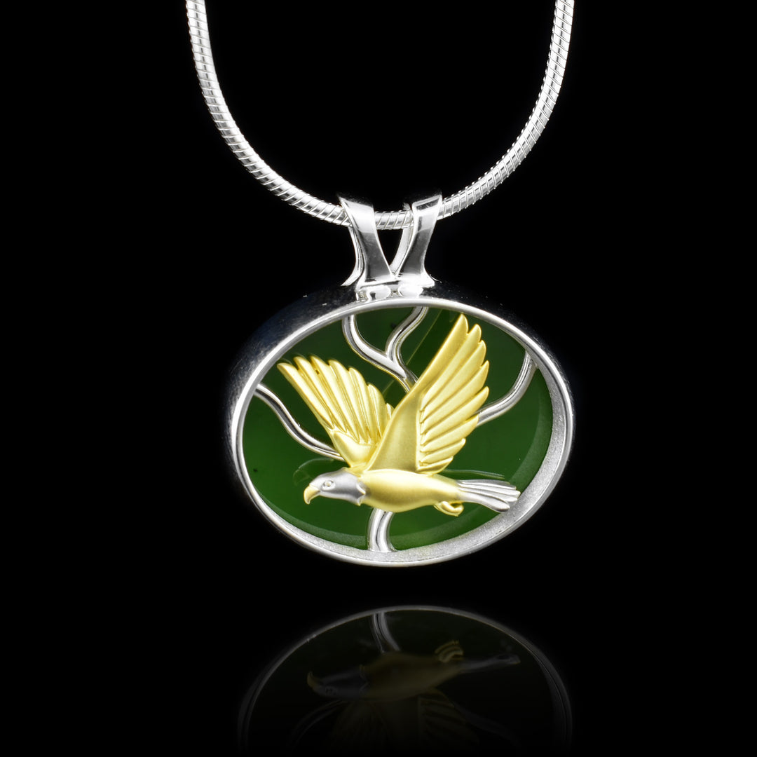 Multi-Metal and BC Jade Eagle Pendant. the BC Jade acts as the background for the gold eagle. the eagle's head and tali is made with Rhodium 