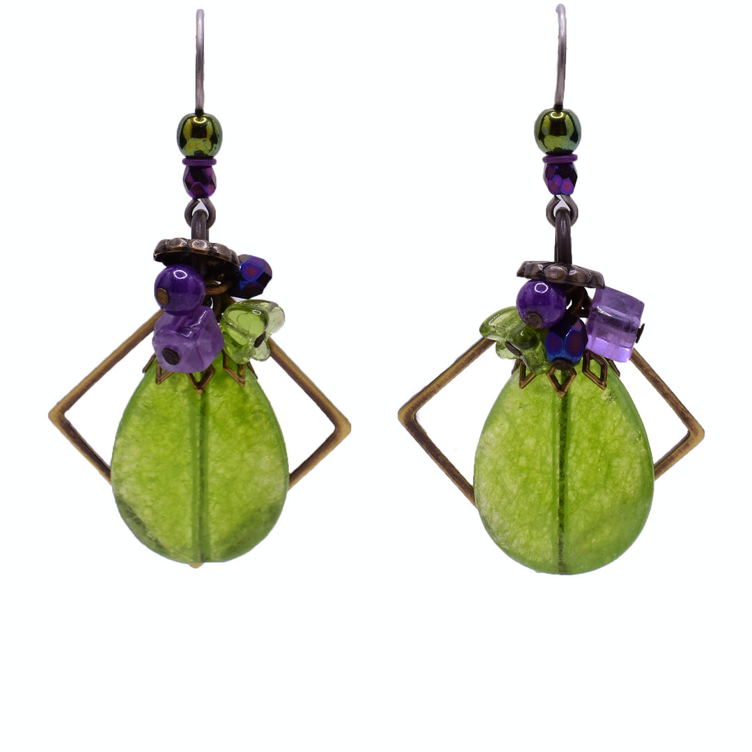 Large dangle earrings made of faceted glass, fossil stone, brass, dyed quartz, amethyst and glass. Titanium hooks. By Honica.