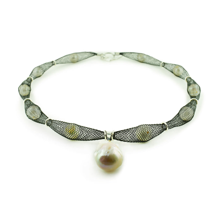 Elevate your style with our artisan black mesh necklace. Lustrous pearls are hand-netted and finished with a bold, organic baroque pearl centerpiece. One-of-a-kind design.