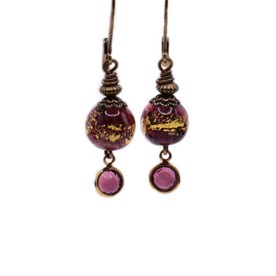 Brass dangle earrings with purple and gold handmade lampworked glass beads and crystals.