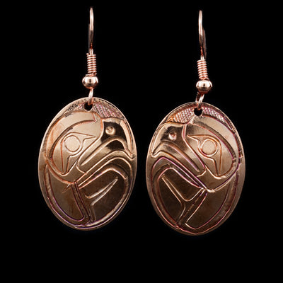 These copper dangle earrings are oval shaped and have carvings depicting the Eagle on them.