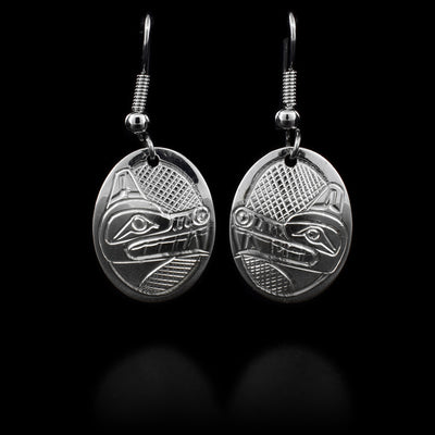 These sterling silver dangle earrings have hooks. There is an oval hang attached to the hook, it depicts the face of the Wolf.
