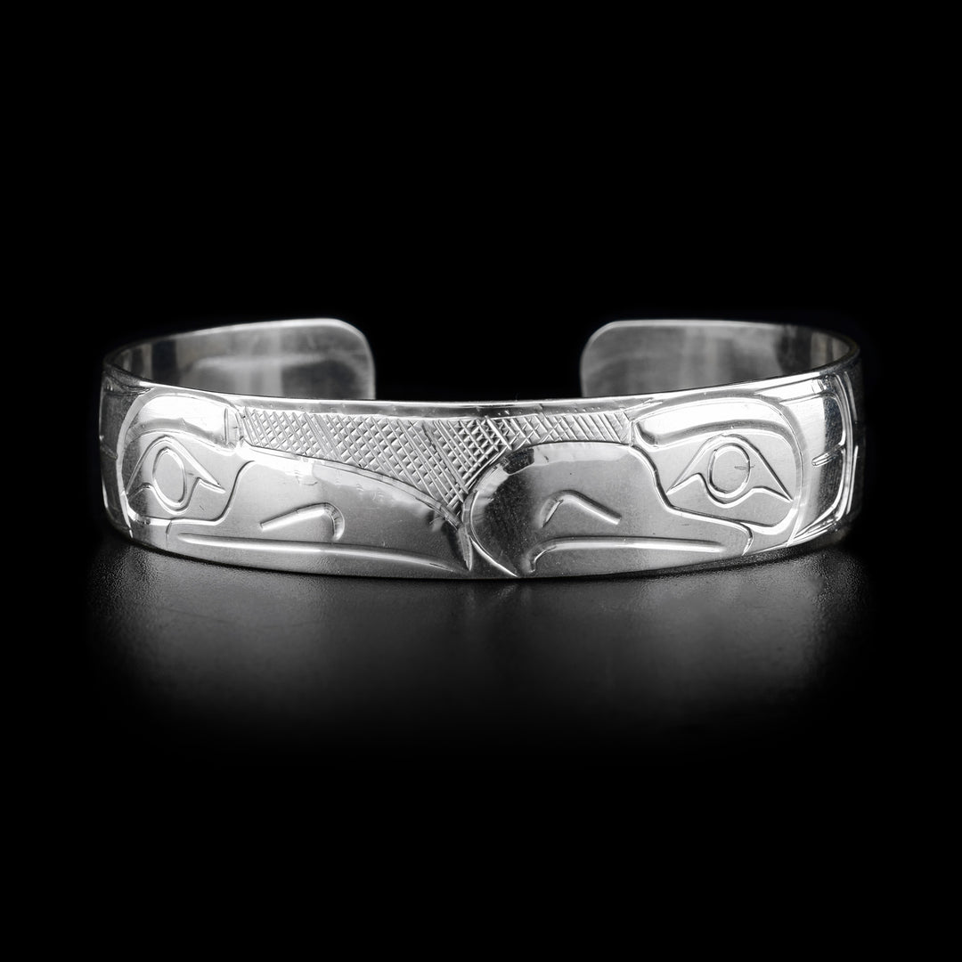 This sterling silver cuff bracelet has depictions of the Raven and the Eagle carved into it. Thier heads meet at the top of the bracelet.