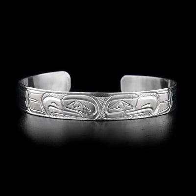 This sterling silver cuff bracelet has two depictions of the Eagle carved into it. Both their heads meet at the top of the bracelet.