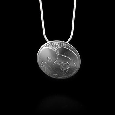 This Eagle pendant is made from sterling silver and is circle shaped. There is a depiction of the face of the Eagle carved into the surface of the pendant.