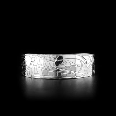 This sterling silver cuff bracelet is wide and has carvings that depict the Wolf on its surface. The band of the cuff is slightly tapered at the end.