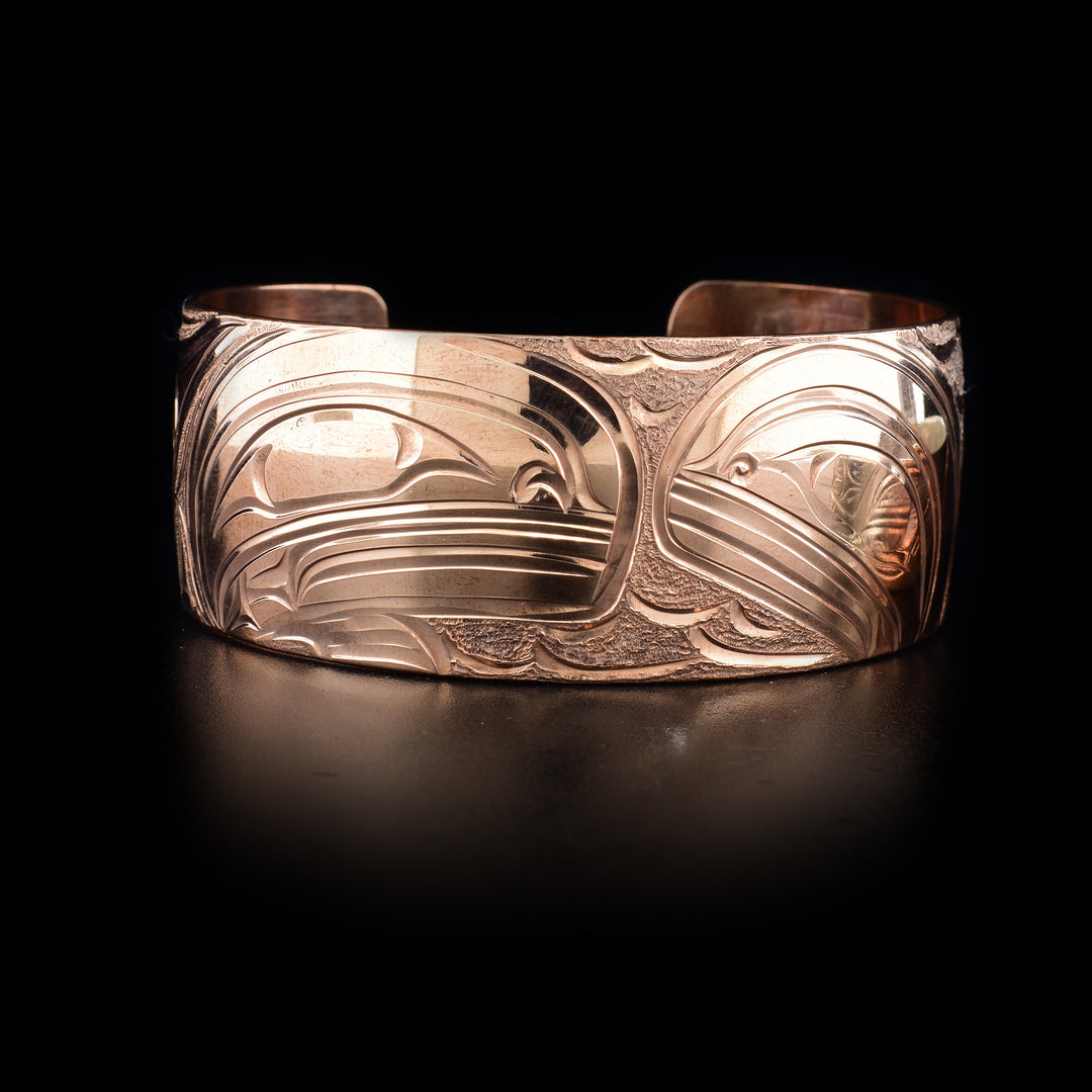 This Orca bracelet is made from copper and has a wide band with a gap in the back. There are three depictions of the Orca carved into the surface of the band.