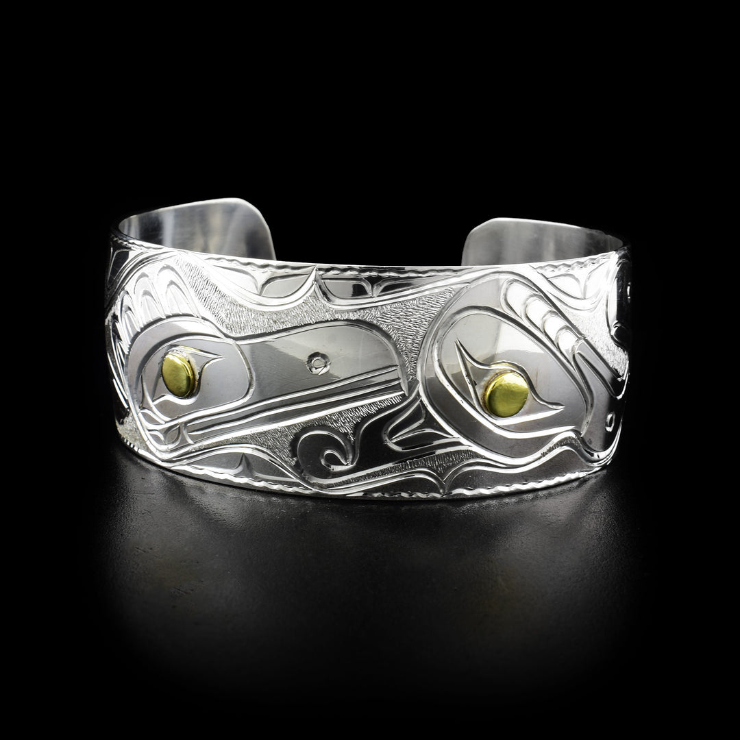 Thunderbird, Raven and Eagle bracelet Cuff: Carved raven and thunderbird head with background designs. Pupils are brass and rest of bracelet is sterling silver.