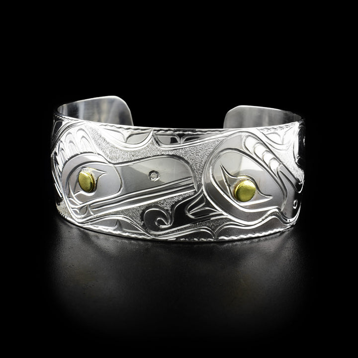 Thunderbird, Raven and Eagle bracelet Cuff: Carved raven and thunderbird head with background designs. Pupils are brass and rest of bracelet is sterling silver.