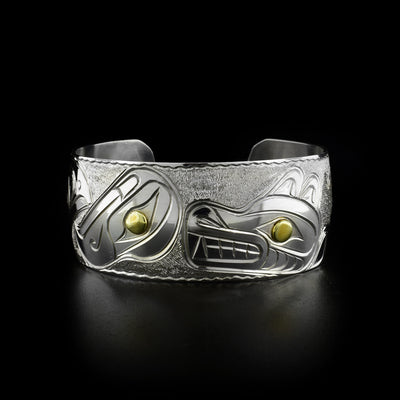Sterling silver 1” wide cuff bracelet featuring an eagle, a raven and two wolves. Brass in eyes. Textured background. Front of bracelet with wolf and eagle.