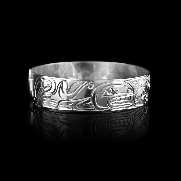 made with sterling silver the legend of the Orca and Salmon are carved into this sterling silver bracelet.