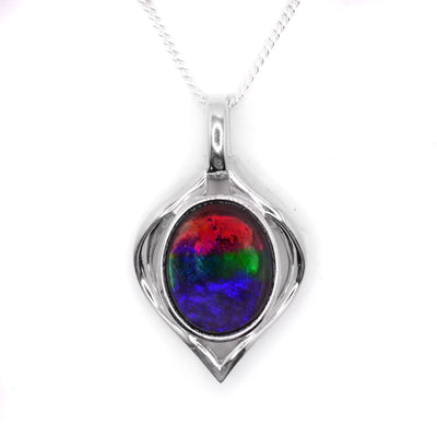 A diamond shaped sterling silver pendant with an oval shaped ammolite piece embedded in the middle.