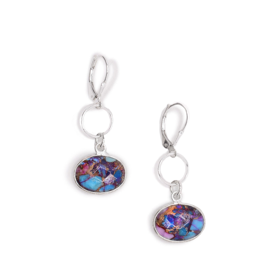 For each earring, a faceted, horizontal oval of oyster shell set in silver dangles from a ring then a lever-back hook. All metal is sterling silver. By Elizabeth Burry.