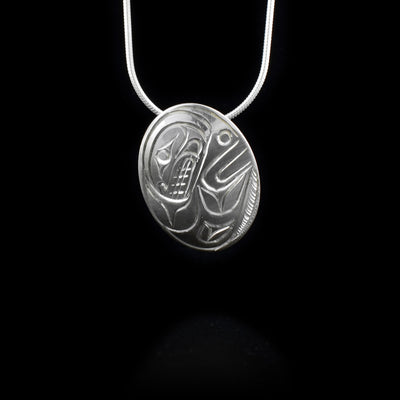 Sterling silver oval orca swimming pendant.