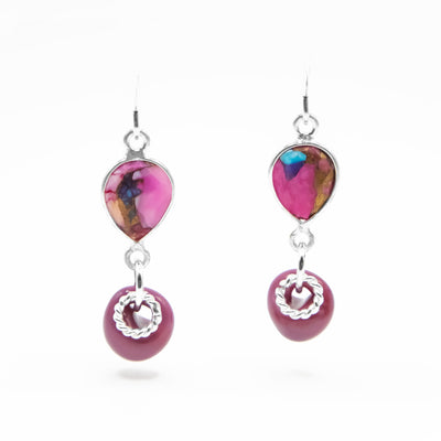Faceted, downward teardrop-shaped oyster shell dangles from hooks. Dark pink glass adornment and silver ring adornment dangle below shell. All metal is sterling silver.