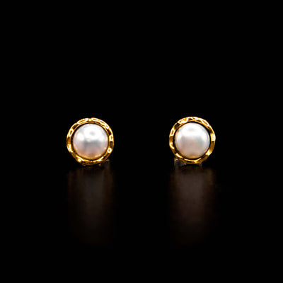 White freshwater pearl stud earrings with 14K yellow gold and sterling silver. Pearls surrounded by round, gold crinkled border. By Ivan Dobren.