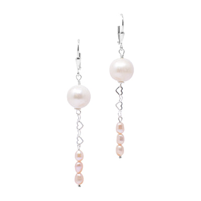 For both earrings, round, cream freshwater pearl at top. Below, silver hearts interlock, leading down to three stacked smaller, cream seed pearls. Lever back hooks. Metal is sterling silver.