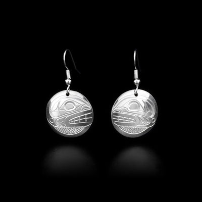 Each earring is a round, sterling silver dangle earring with an orca head and a cross-hatching background. By Kwakwaka’wakw artist Don Lancaster.