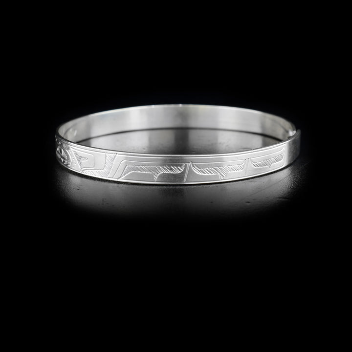 Left side of bracelet with carved designs that resemble a wing.
