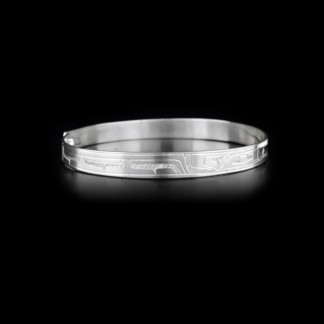 Right side of bracelet with carved designs that resemble a wing.