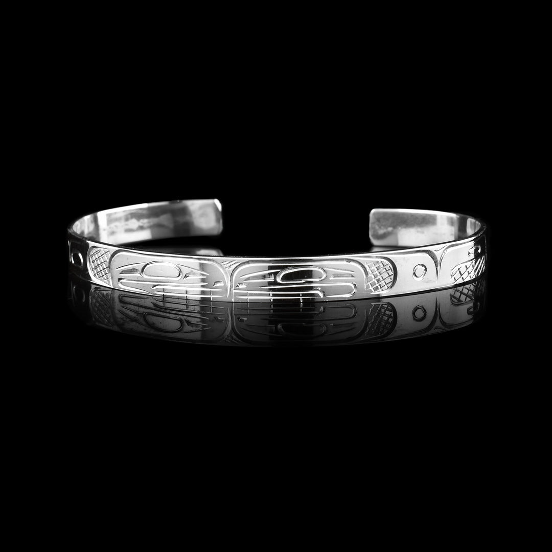 This quarter inch  Double Orca Bracelet Cuff is made from sterling silver where the Indigenous Orca legend is carved into the surface.