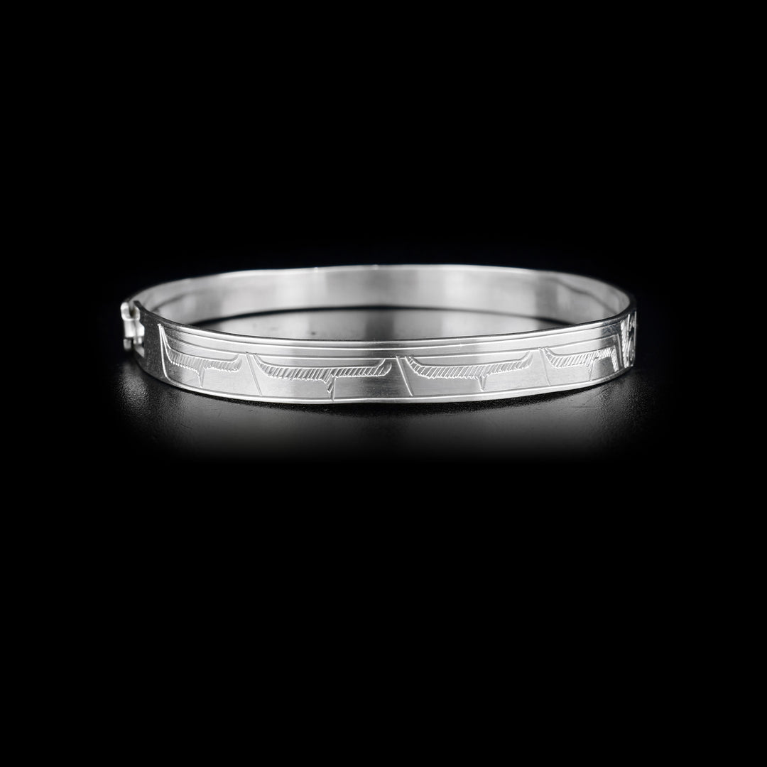 Right side of bracelet with carved designs that resemble a wing.