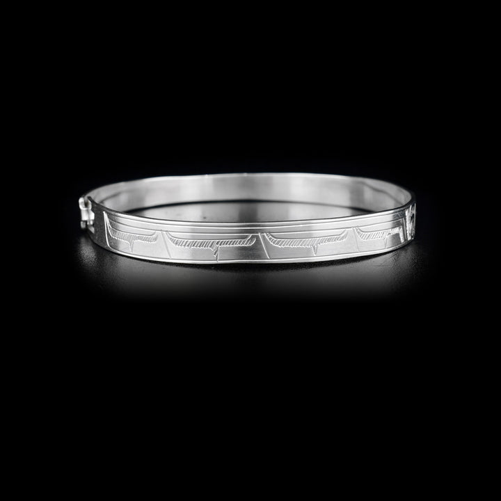 Right side of bracelet with carved designs that resemble a wing.