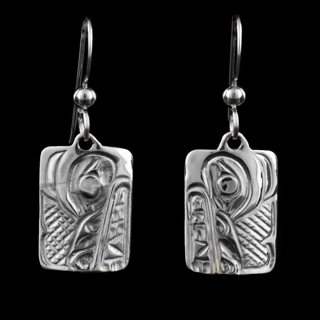 These rectangle dangle earrings hang from French hooks. The design is a classic indigenous wolf carved into small rectangular pieces of sterling silver. 