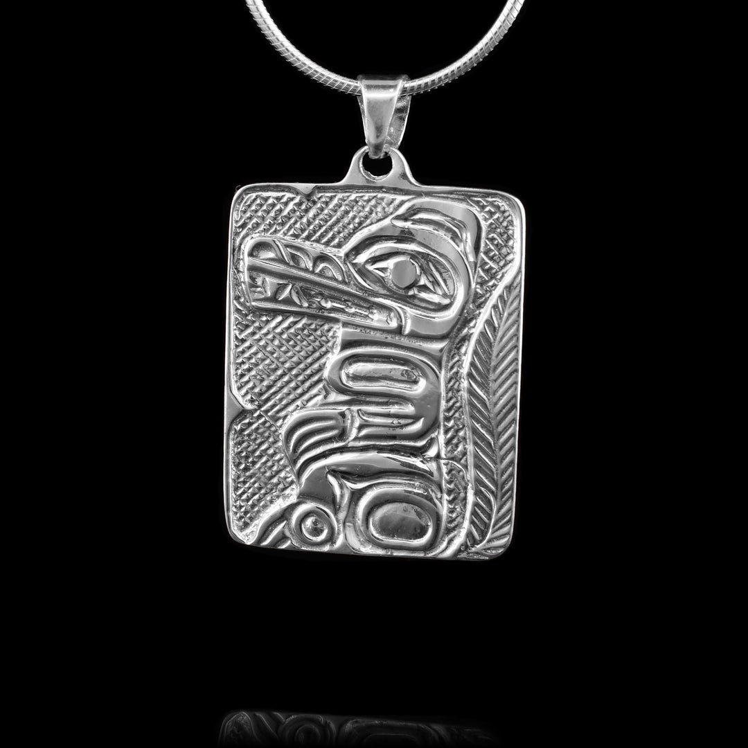 This rectangular sterling silver wolf pendant has been carved with a full body indigenous legend of the wolf. 
