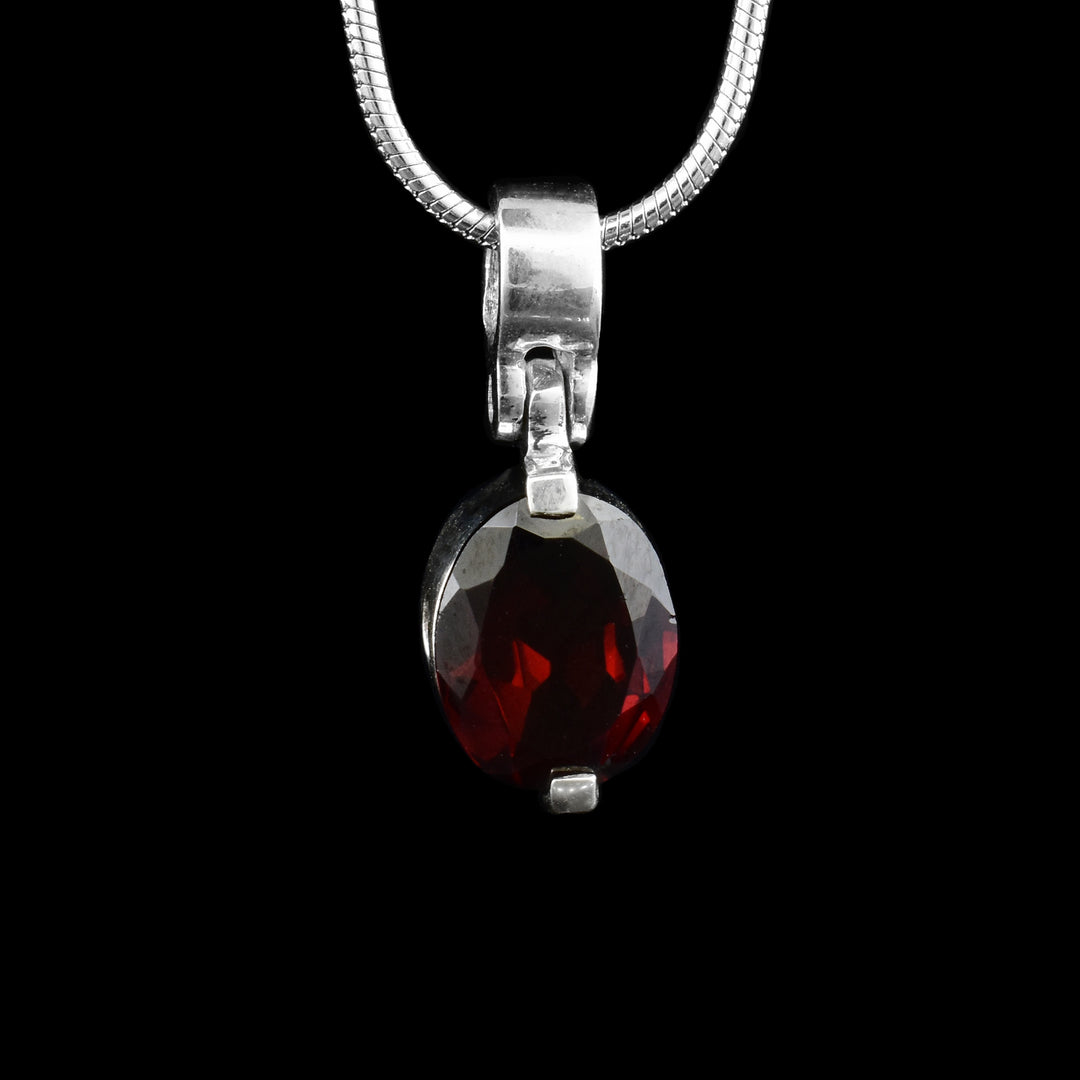 Red oval garnet attached to a sterling silver clasp pendant