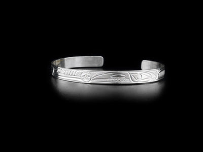 This sterling silver cuff bracelet is thin and has carvings that depict the Wolf and the Raven facing the Moon.