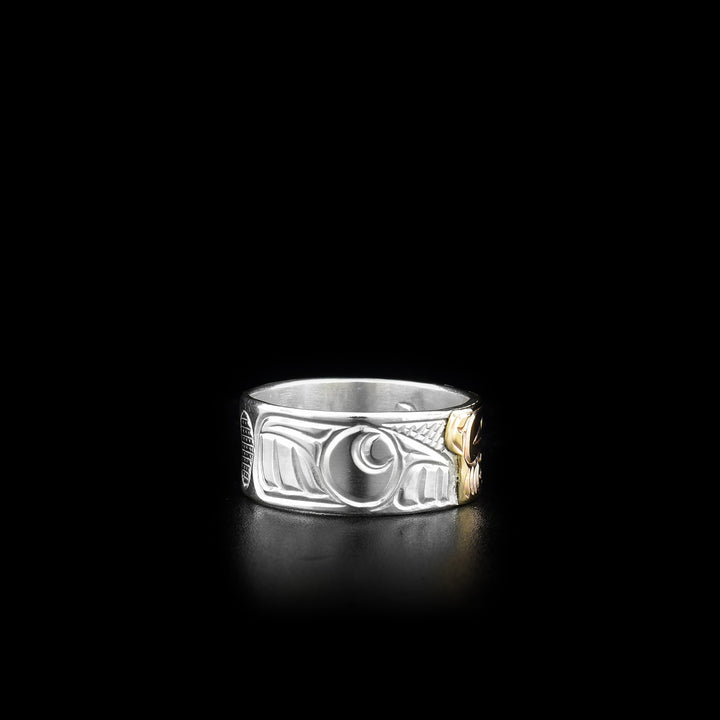 This sterling silver and 14K gold ring has carvings all over the surface of the band. There is a depiction of the Bear carved into the piece and the face of the Bear is made from 14K gold.