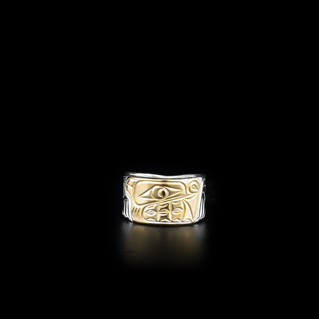 This sterling silver and 14K gold ring has a tapered band and there is a depiction of the Bear carved into the surface of it. The face of the Bear is made from 14K gold.