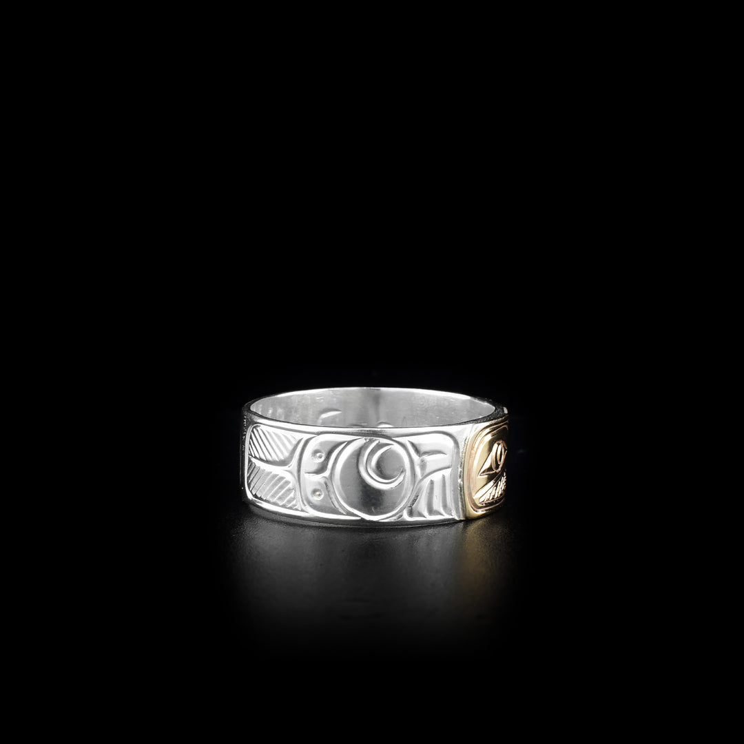 This sterling silver and 14K gold ring has two depictions of the Eagle carved into the surface of the band. The Eagles are depicted facing each other and their heads are made from 14K gold.