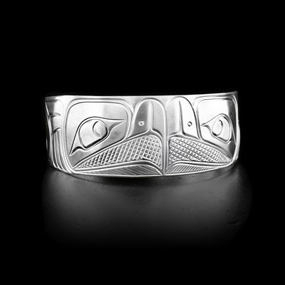 A sterling silver bracelet that has two Eagles handcarved in the middle. They are facing eachother.