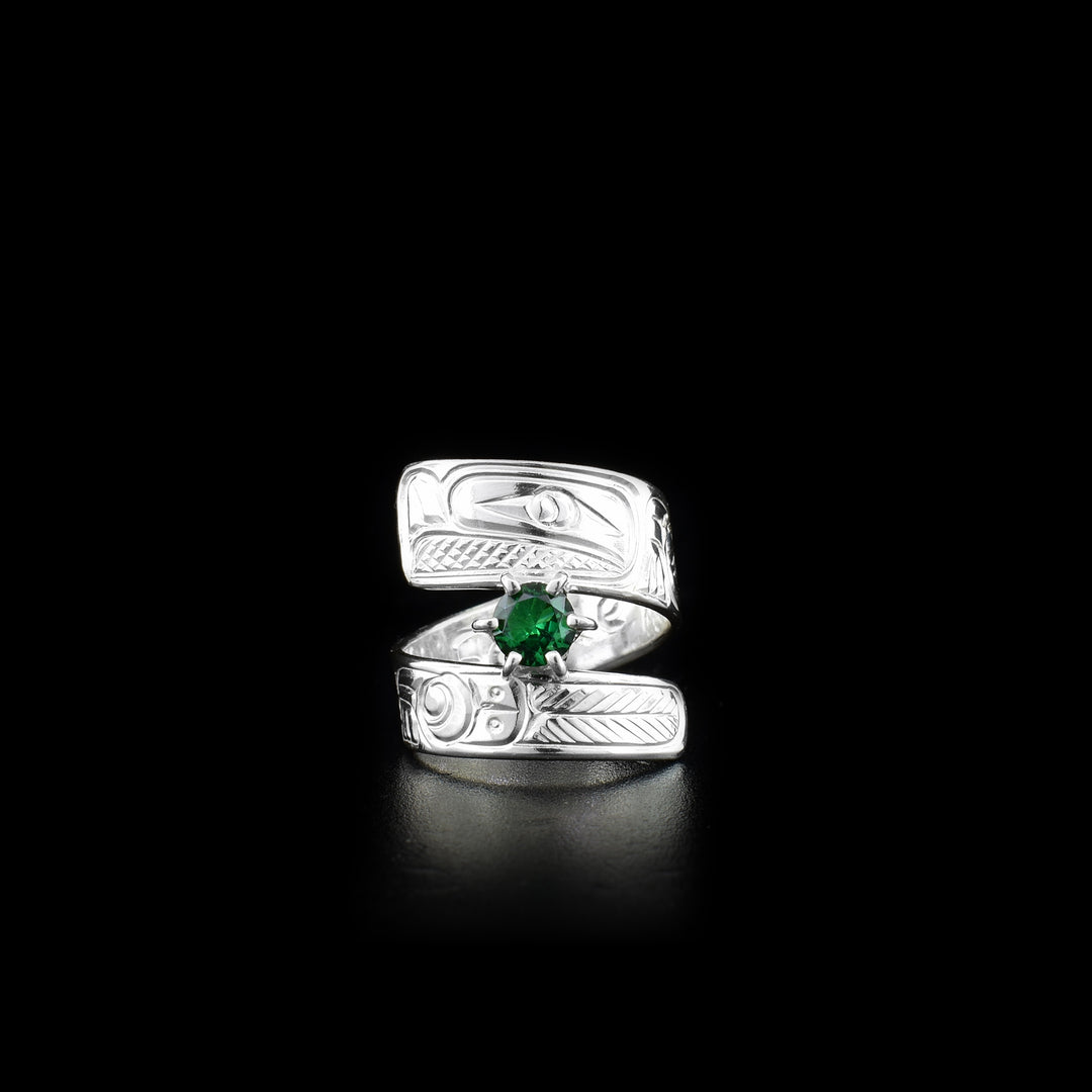 This green gemstone ring is made from sterling silver and has a wrapped, tapered band. There is a depiction of a flower and the Eagle carved into the surface of it.