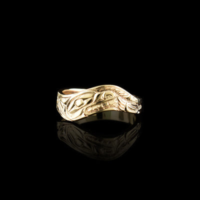 This wavy band ring has a thin, 14K gold band with a wavy appearance. There is a depiction of a side view of the head of the Wolf carved into the surface of the band. Around the head, other details of the Wolf are carved.