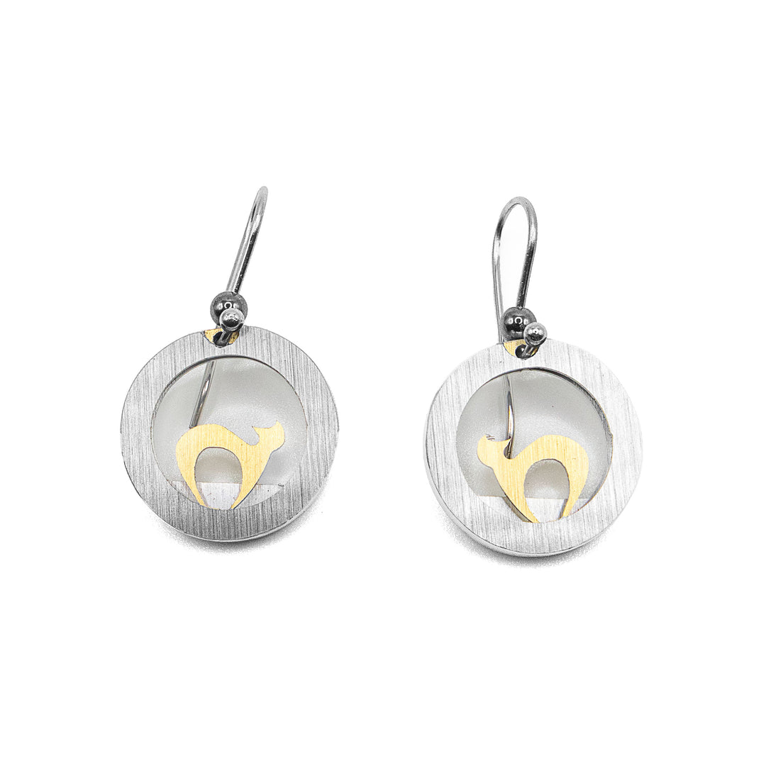 Both earrings are a silver-coloured frame with a gold-coloured cat silhouette inside. Cat’s head is turned so both ears are visible. Made of brushed and anodized aluminum. Stainless steel hooks. By JR Franco.
