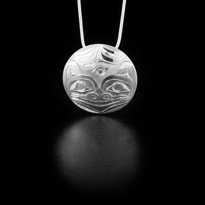 Pendant depicts bear. Background is cross-hatching. Hidden bail on back. By Haida artist James McGuire.