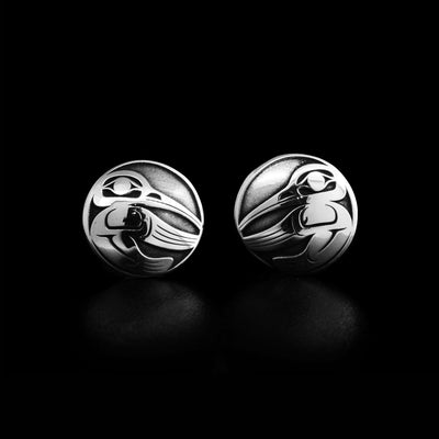 Laser-carved, oxidized background emphasizes the three-dimensional design. Both earrings depict the side-view of a hummingbird with wing outstretched. By Tahltan artist Grant Pauls.