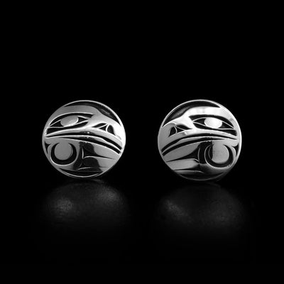 Laser-carved earrings with oxidized background emphasizing three-dimensional design. Both earrings have the side-view of a raven’s head and outstretched wing. Made of sterling silver. By Tahltan artist Grant Pauls.