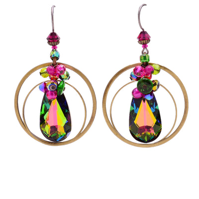 On both earrings, brass hoops dangle from a titanium hook. Teardrop Swarovski crystal with blue, green, violet, pink and orange hues dangles in the hoops. Beads with same colours adorn the earrings above the teardrop.