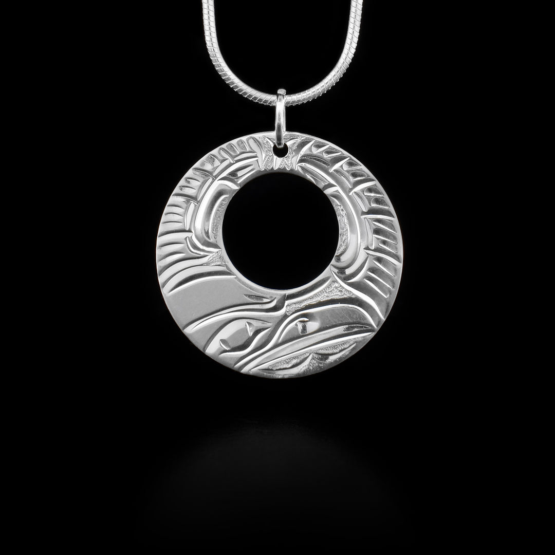This raven pendant has cut out circle and features a raven. Jump ring for bail. Hand-carved by Kwakwaka’wakw artist Cristiano Bruno.