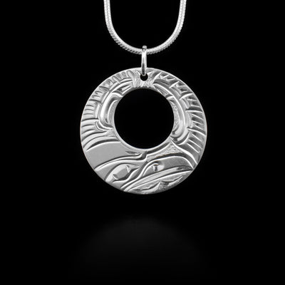 Pendant has cut out circle and features a raven. Jump ring for bail. Hand-carved by Kwakwaka’wakw artist Cristiano Bruno.