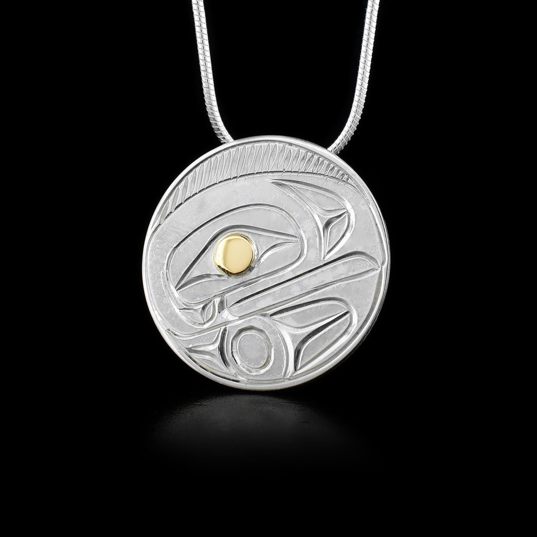 Round, flat pendant featuring raven. 14K yellow gold in eye. Hidden bail on back. Hand-carved by Kwakwaka’wakw artist Paddy Seaweed.