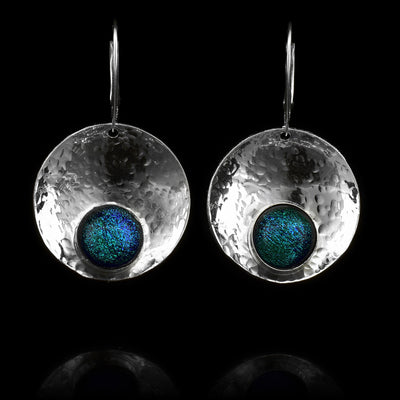 These circle dangle earrings are made using sterling silver and brilliant green fused glass beads. The hangs are circle shaped and embossed into a concave shape. The glass beads have interesting patterns in  them and are displayed at the bottom of the hangs.