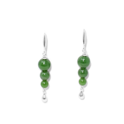 Each earring has three, stacked round grade A BC jade beads. Largest bead on top is 0.4” in diameter. Lever-back hooks. Silver teardrop adornment hangs on bottom. All metal is sterling silver.